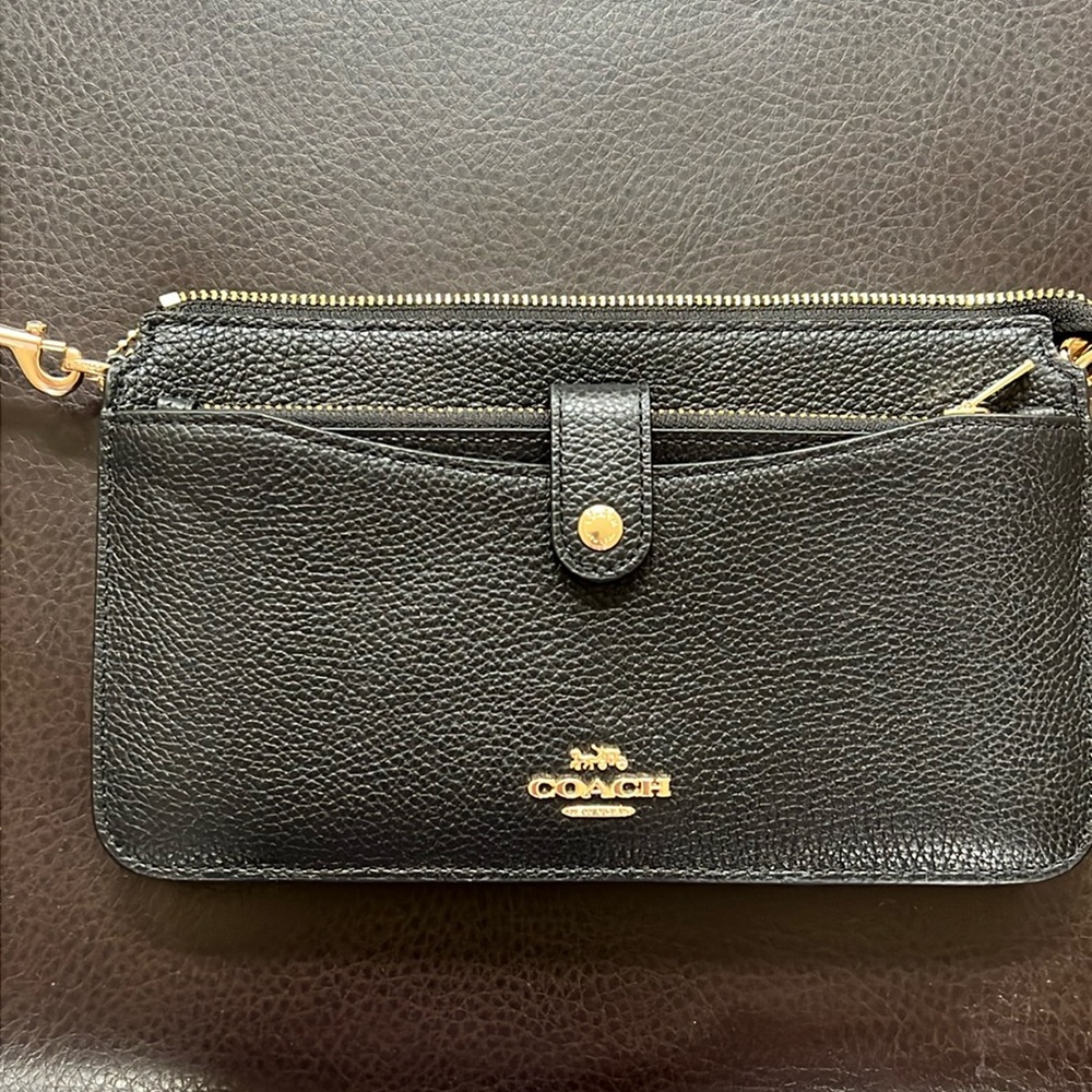 Coach small purse in black pebbled leather with brass hardware.